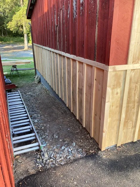 Barn wall repair with new vertical wood siding