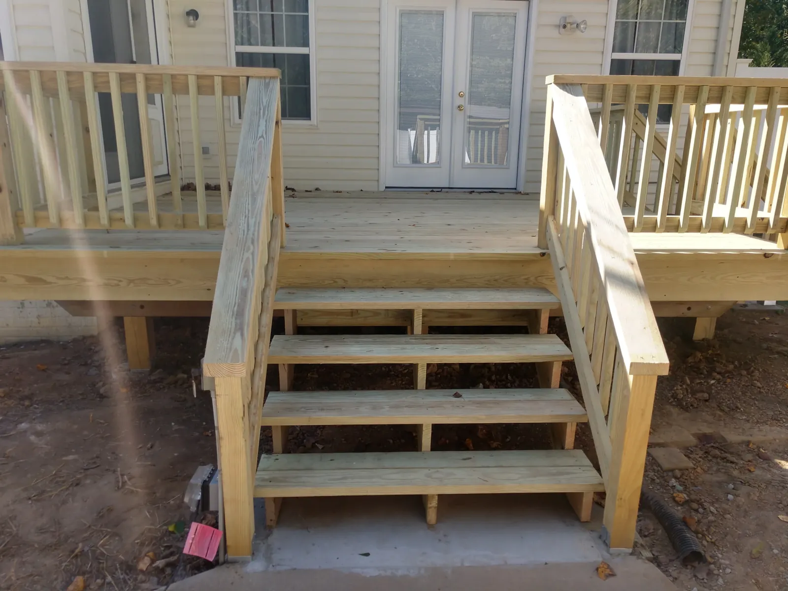 New pressure-treated wood deck stairs with matching railings